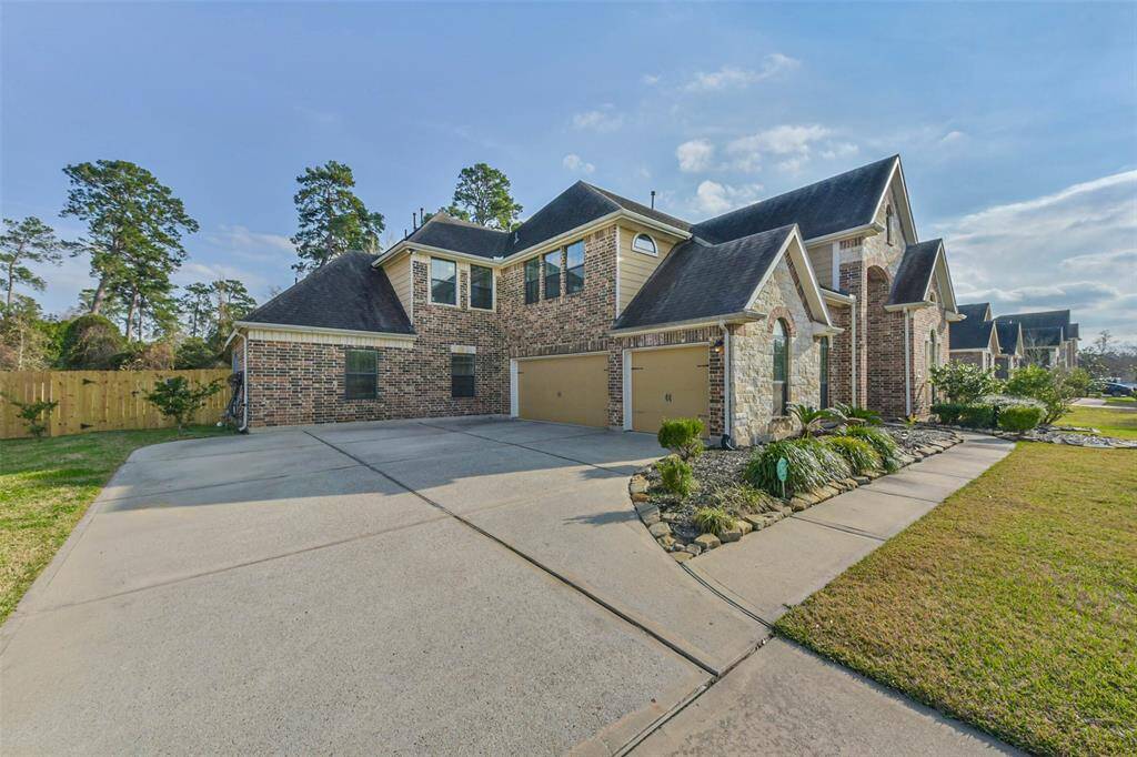 The property features a spacious driveway that leads to a three-car garage