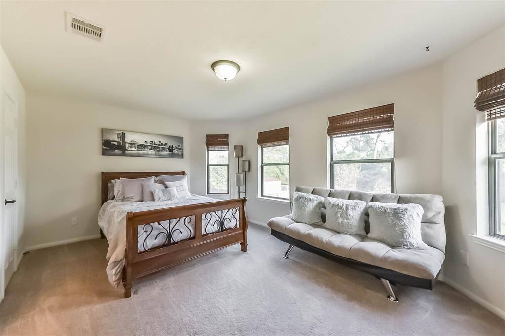 Bright third upstairs bedroom filled with natural light from multiple windows.