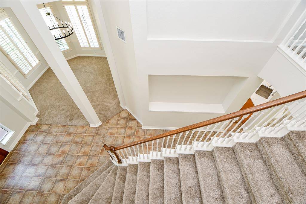 This photo shows a spacious, well-lit home interior. Large windows with shutters allow natural light to fill the space, enhancing the open feel.