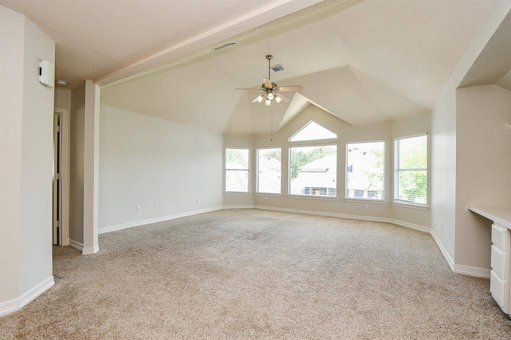 Spacious and bright game room with vaulted ceilings and large windows.