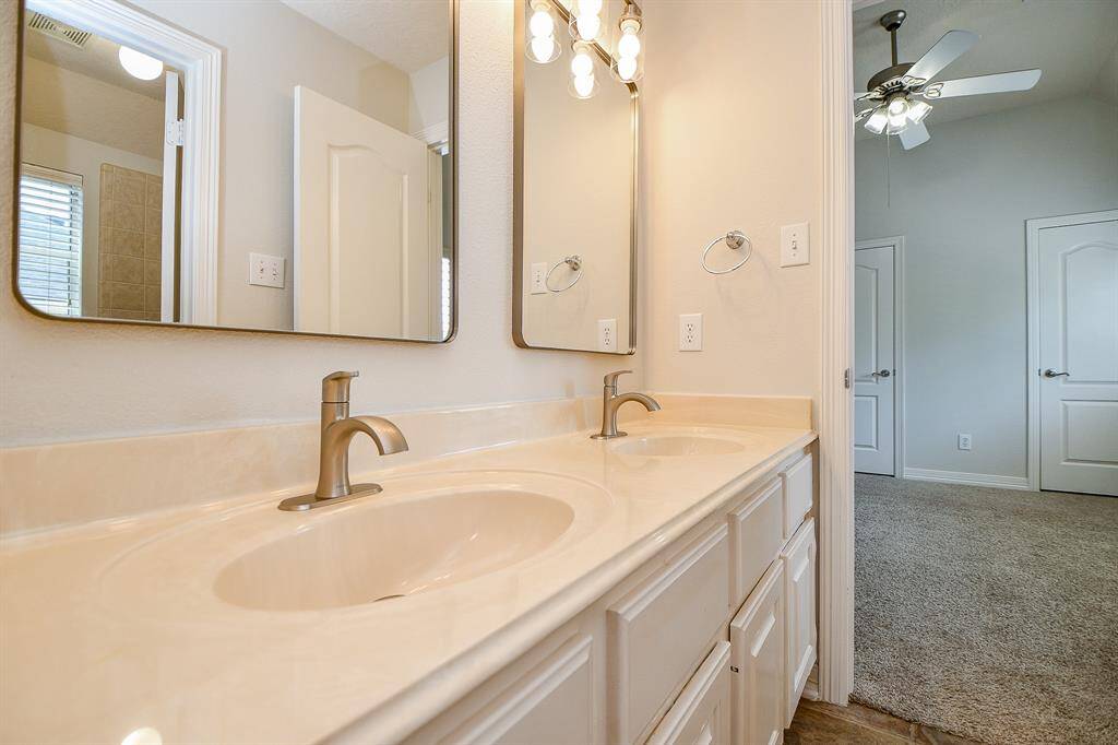 Discover the elegance of the secondary bathroom, featuring dual sinks, modern fixtures, and ample lighting for a refreshing experience.