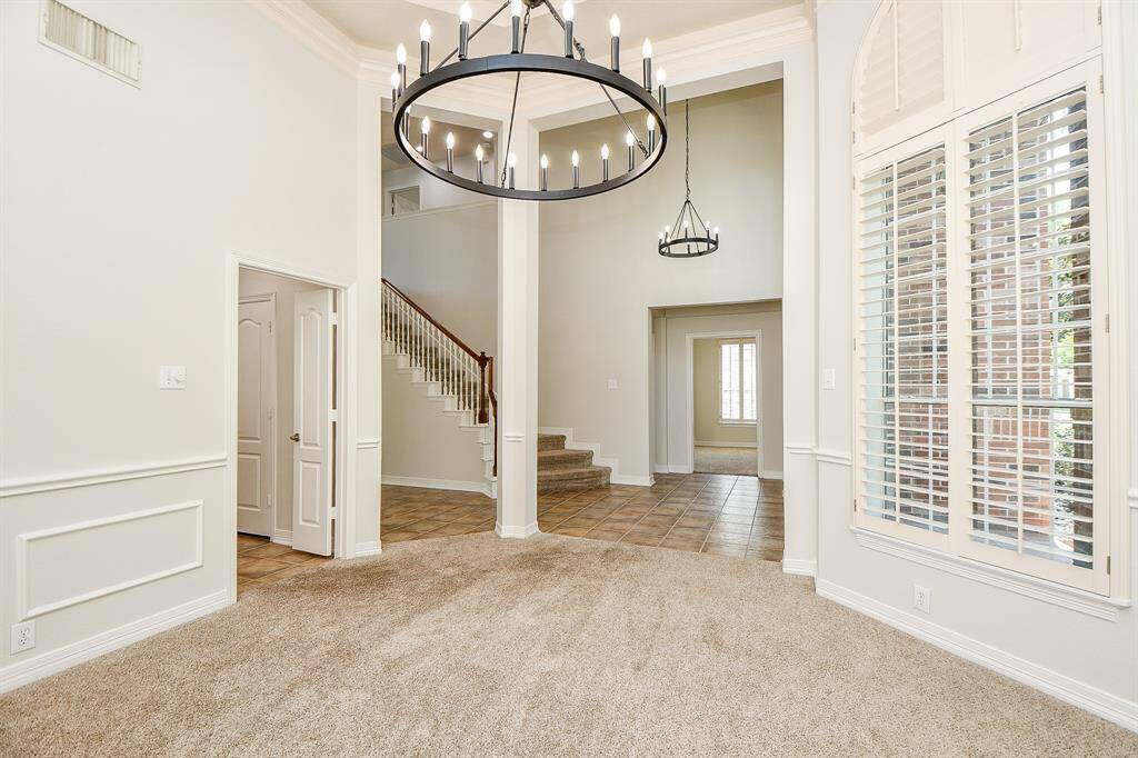 Elegant formal dining area with high ceilings, large windows, and a striking chandelier—perfect for hosting memorable gatherings.