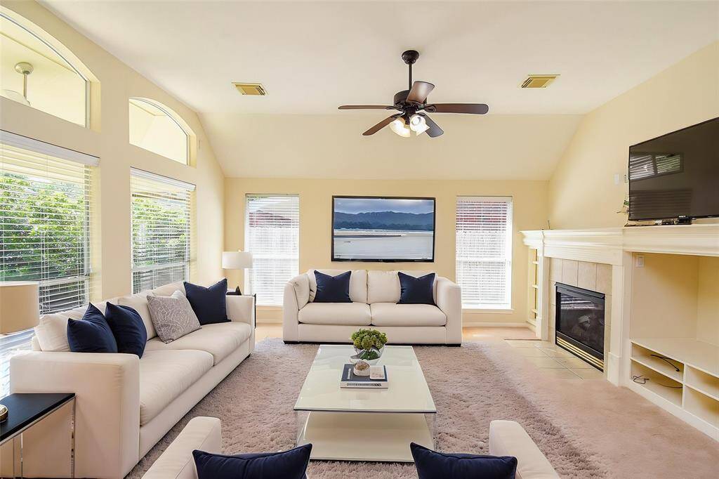 The spacious family room is filled with natural light, thanks to large windows that offer a beautiful view of the lush backyard. With easy access to the kitchen and breakfast area and an open-concept layout, it’s the perfect space for relaxing or entertaining. Virtually staged photo.