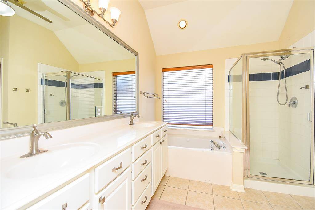 The primary bathroom offers a spa-like feel with a soaking tub, separate stand-up shower, and double vanities.