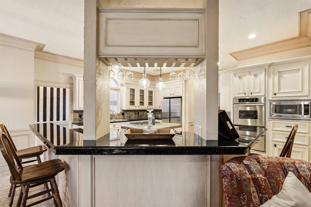 Wall-to-wall cabinets, built-in fridge, and pendant lighting.