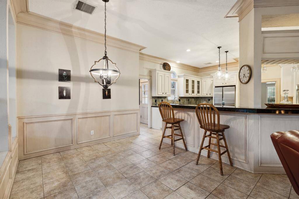 Spacious breakfast nook with elegant lighting and views of the kitchen.