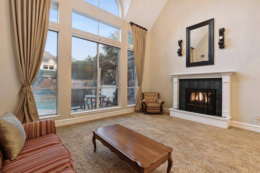 Abundant natural light and fireplace overlooking the backyard pool.