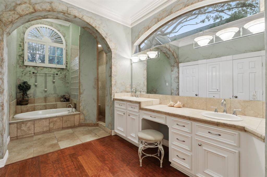 Spacious bathroom with double vanity, marble counters, and soft lighting.