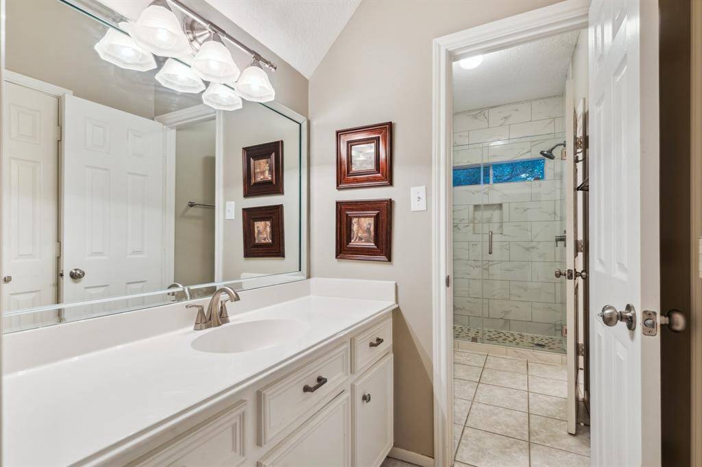 Bright bathroom with extended vanity, framed mirror, and sleek lighting.