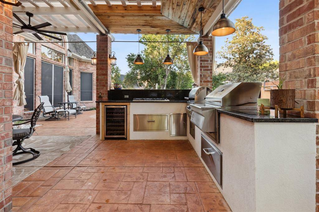 Beautiful outdoor kitchen with multiple cook tops and place to dine.