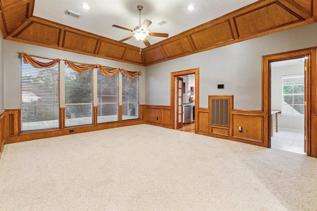 Spacious upstairs game room with custom wood trim and backyard view.