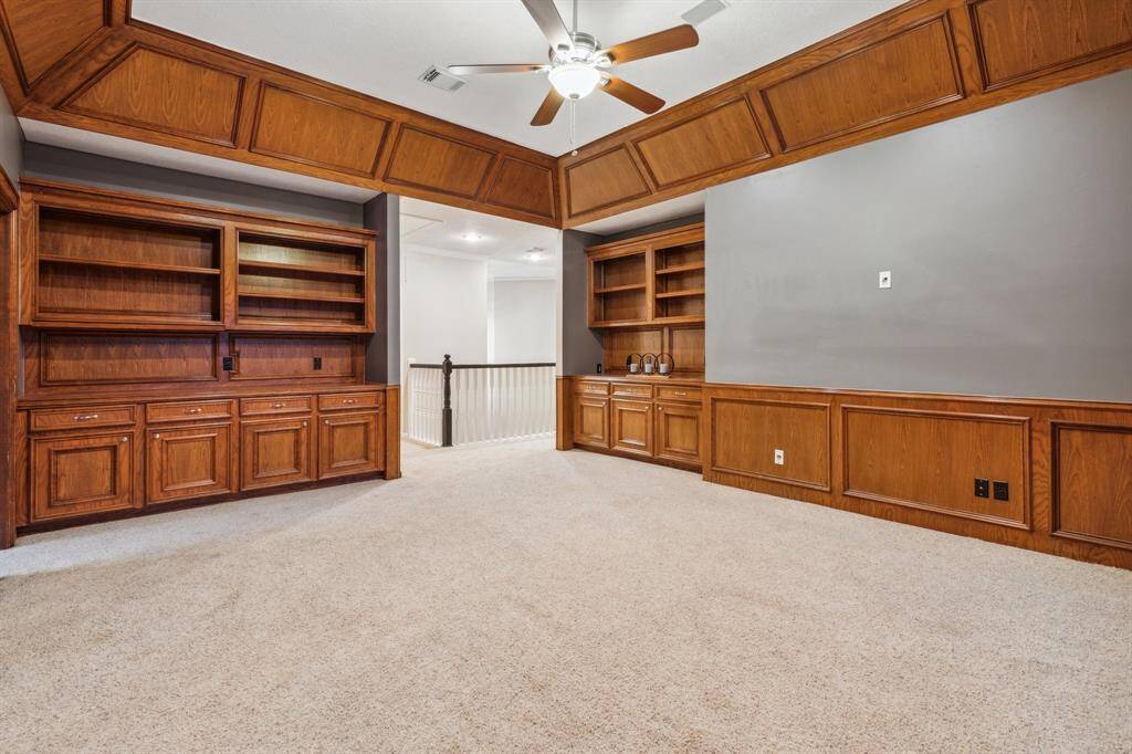 Custom built-ins and wall paneling make this a great media or library space.