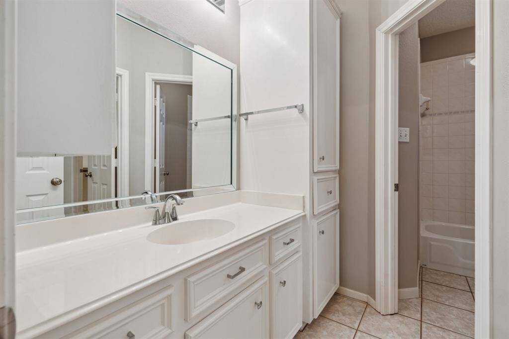 Bright and clean full bath with extended vanity and private shower-tub area.