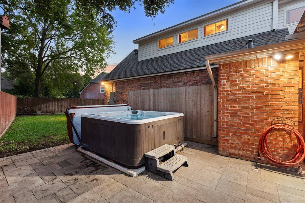 Relaxing hot tub setup on a stone-paved section with privacy and charm.
