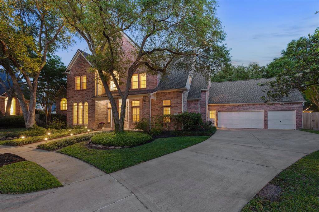 Wide driveway and 3-car garage showcased with the full curb appeal of the home.