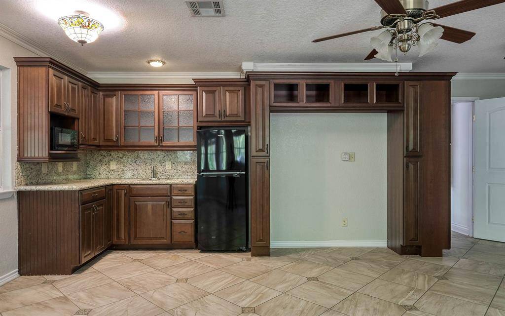 Apartment suite kitchen area with granite countertops, fridge and cabinet space!