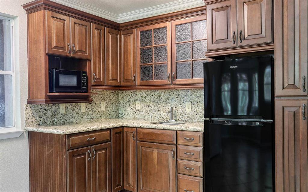 Apartment suite kitchen area with granite countertops, fridge and cabinet space!