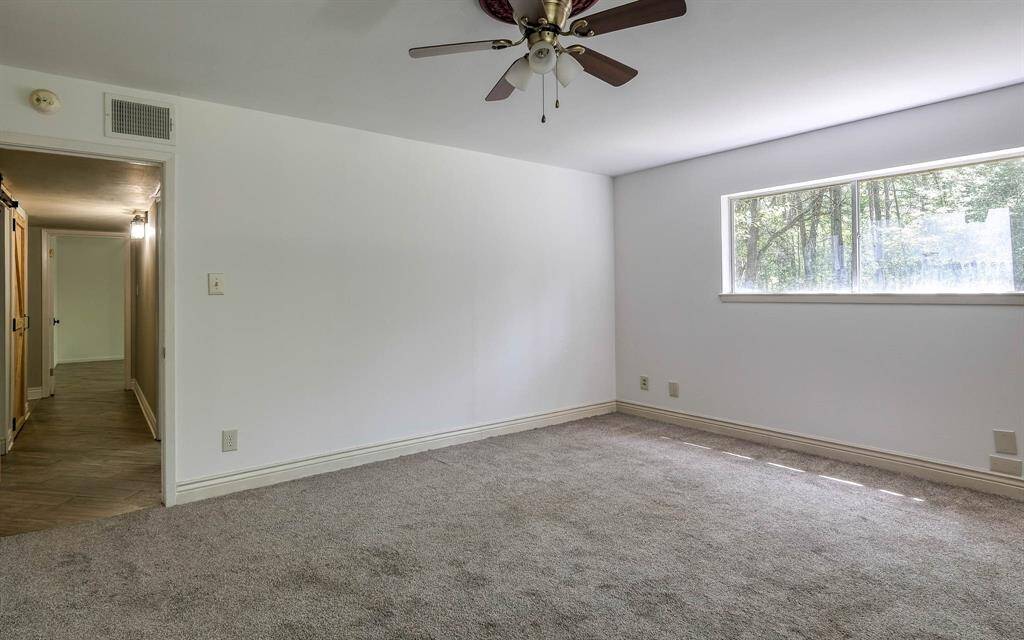 Primary bedroom with ceiling fan! Hallway to the left has washer and drier!