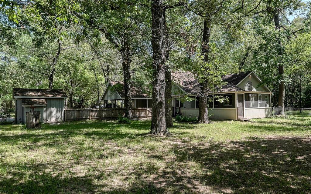 Southeast view from the back yard with the well house to the left, carport in the center and screened in porch to the right!