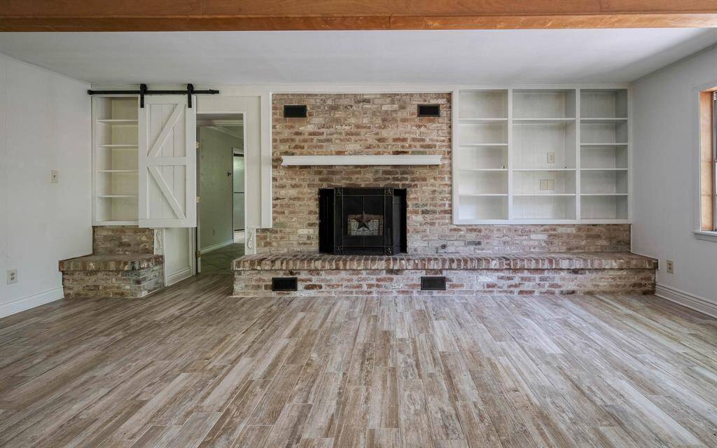 Brick fireplace with bookcase. The barn type door leads into the apartment suite!