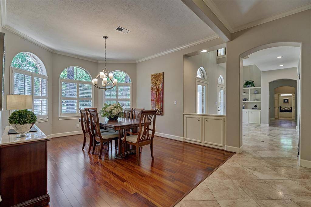 Spacious dining room with wood flooring sits at the front of the home with view of the serene front grounds through the plantation shutters!