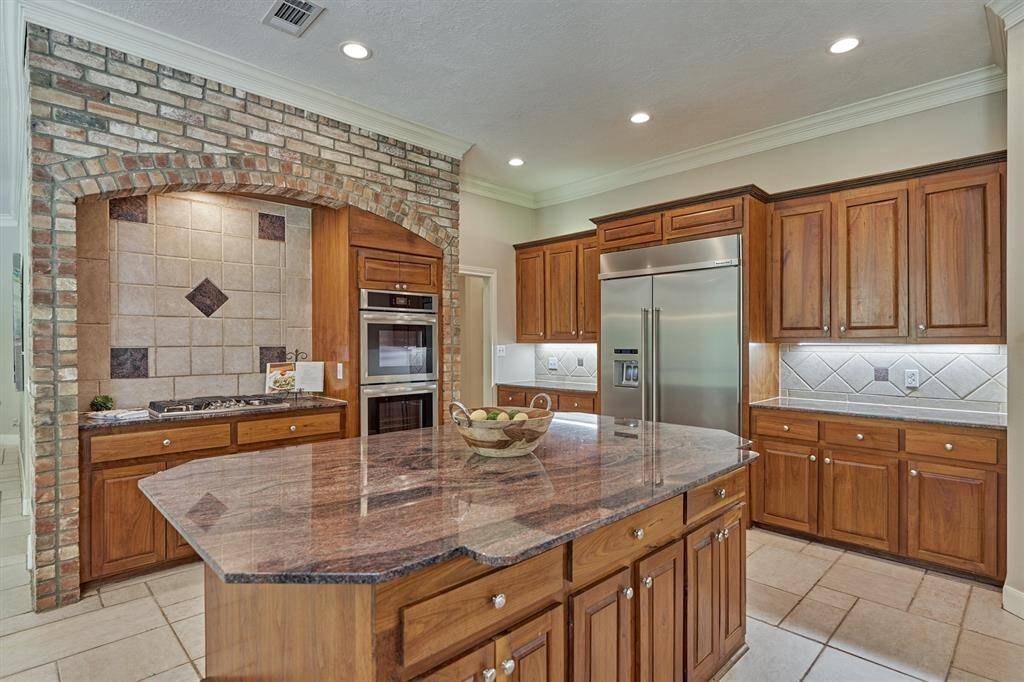 Brick-encased cooking hearth adds a touch of rustic elegance to the kitchen.