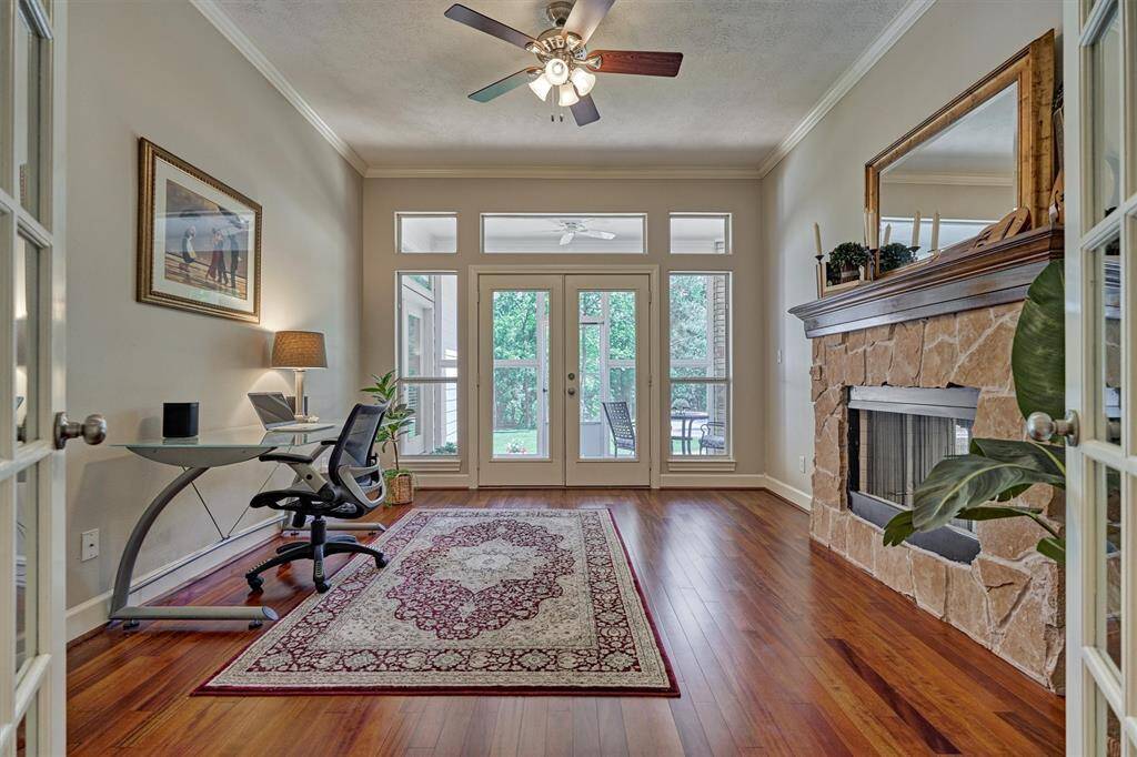 Handsome enclosed study shares a dual-sided fireplace with the formal living room and has access through double doors out to the screened in patio.