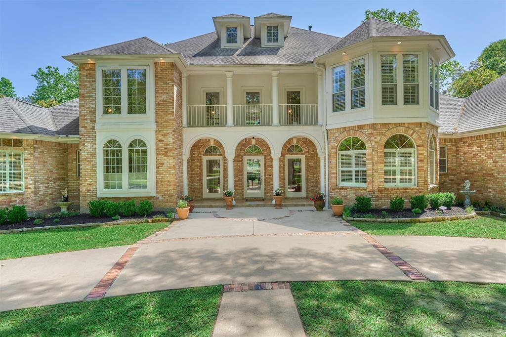 Classic Southern style with covered porch entry with arched openings, transom windows, large 2nd floor balcony, turret roof extension and dorm windows for extra dressing and architectural zeal!