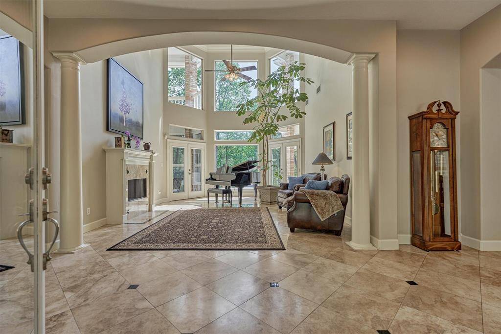 Step inside to continuous travertine flooring and soaring sight lines that extend through dramatic windows in the two-story living room towards a slice of paradise!