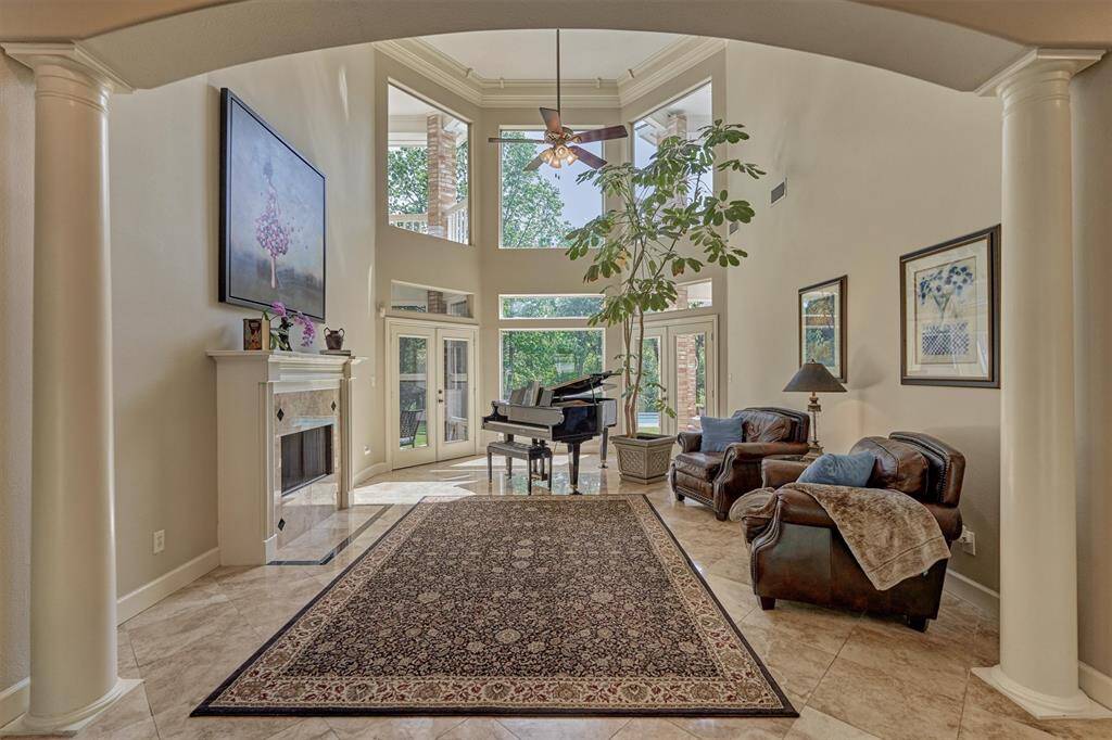Floor-to-ceiling windows bring the outside in via sets of French doors to the outdoor terrace. Note the dual-sided fireplace that connects to the study.