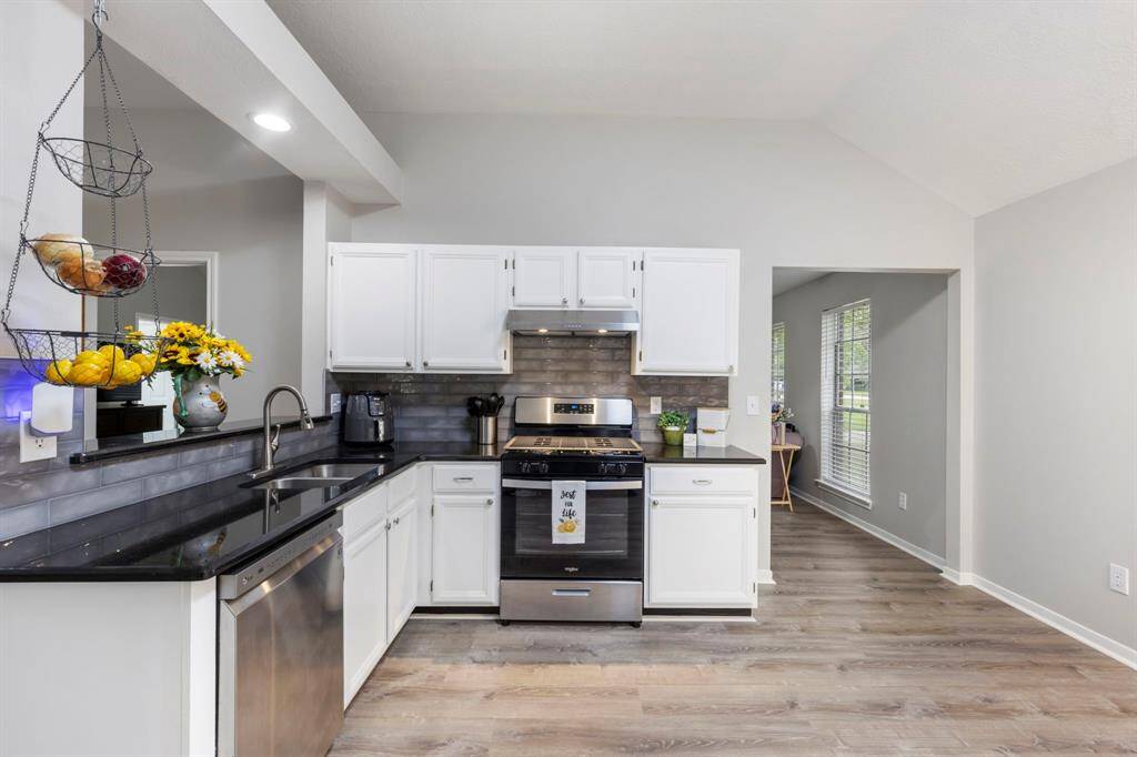 Admire the freshly painted cabinets, stylish new hardware, modern backsplash, and sleek countertops - all paired with generous prep space for effortless cooking!