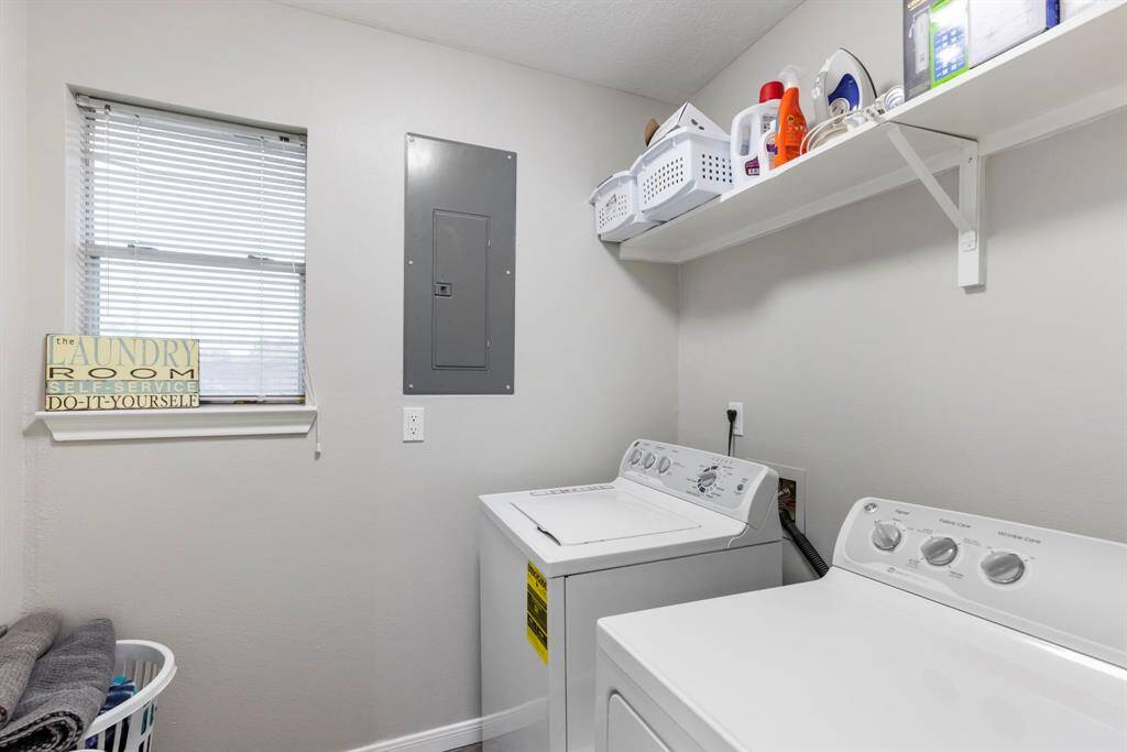The conveniently located indoor utility room features a built-in shelf, perfect for keeping detergents and cleaning supplies neatly organized.