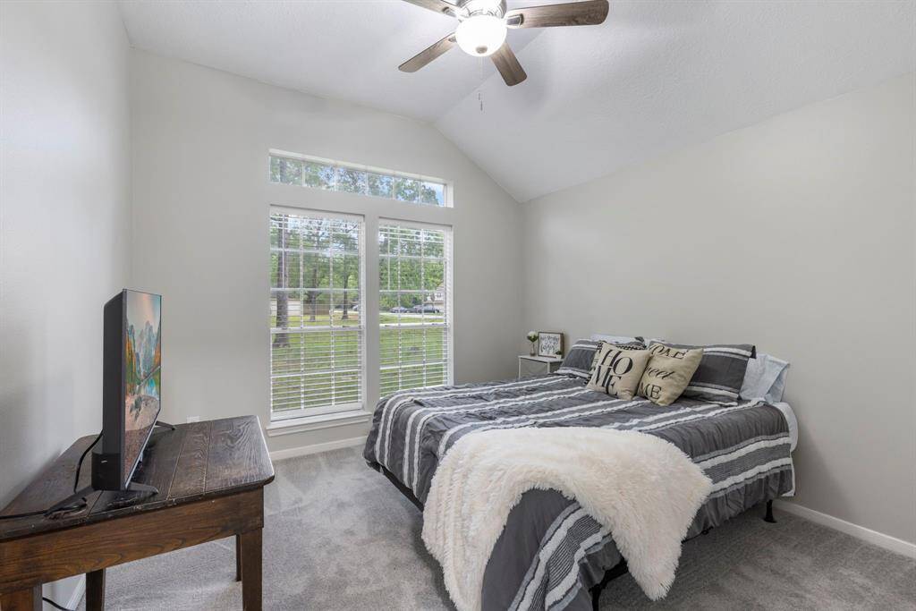 This roomy secondary bedroom offers easy access to the adjacent bathroom, perfect for guests or family.