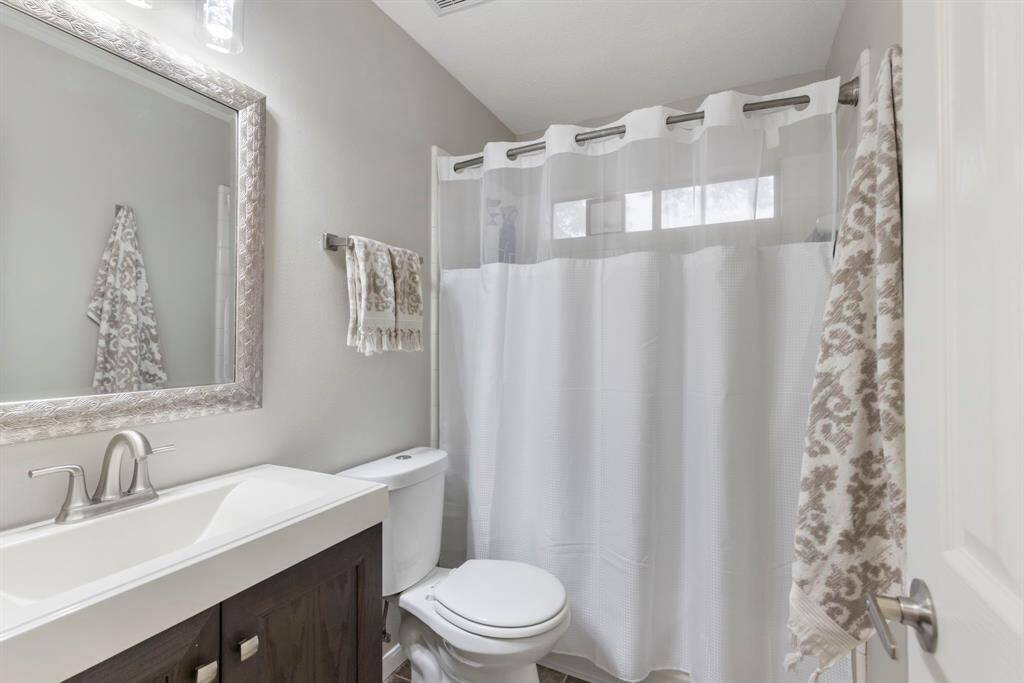 This remodeled bathroom boasts a stylish new vanity, modern framed mirror, and updated toilet, blending form and function beautifully.
