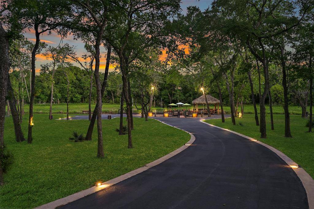 A closer view as you make your way down the path to the waterfront retreat. Outdoor lighting, installed by Texas Outdoor Lighting, showcases the beauty of the entire 3.788 acres making the entire property easy to enjoy day & night!