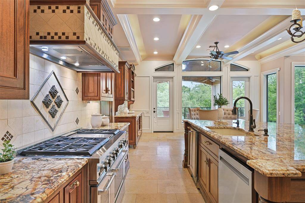 A 6-burner gas range with griddle and double ovens, under cabinet lighting & beautiful vent hood add to the amenities offered.