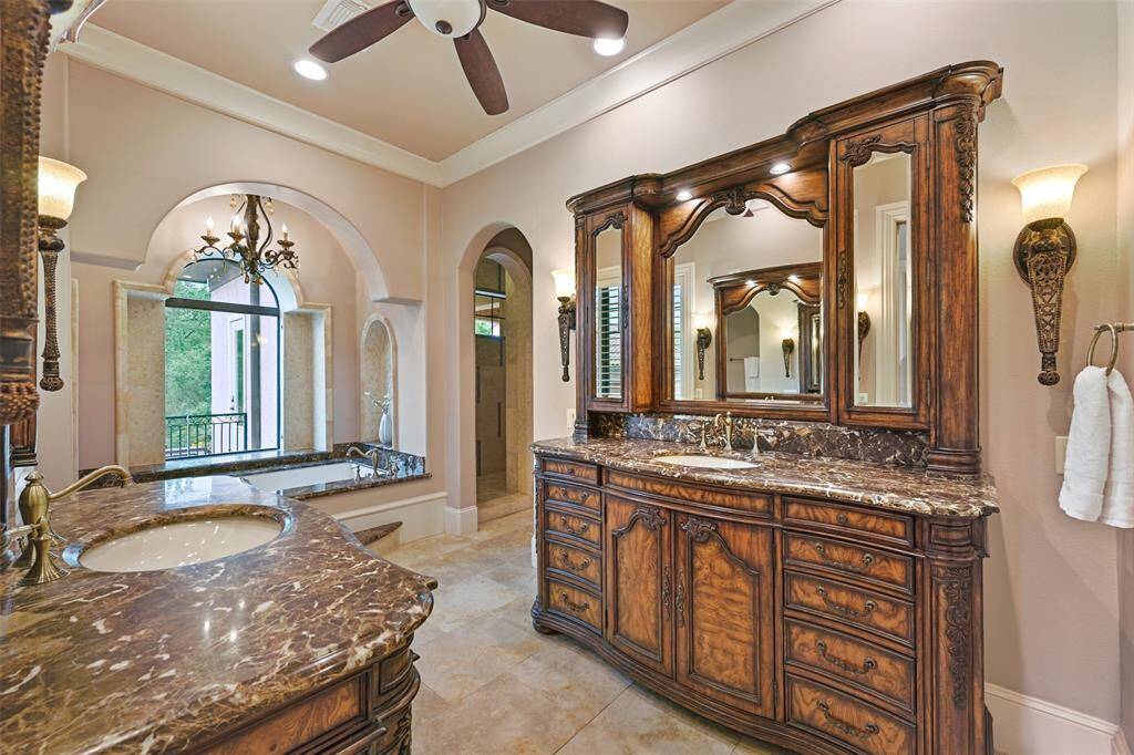 The primary ensuite bath features elaborate vanities, a large soaking tube with intricate stone and tile surround, a large walk-in shower & huge master closet with built-ins and 2 levels of clothing racks.