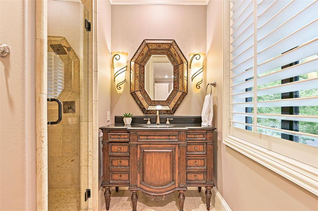 Secondary ensuite bath #1 features a beautiful wood vanity and walk-in shower.