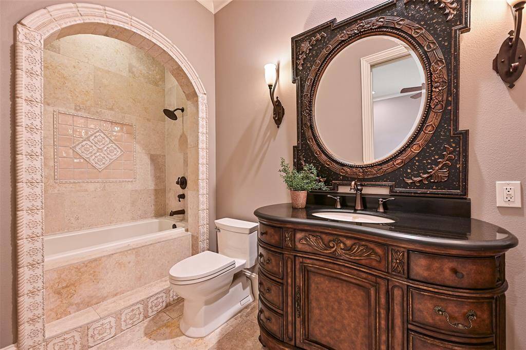 Ensuite bath #2 gracefully hosts a beautiful shower/tub combination with the most stunning stone and tile selections.