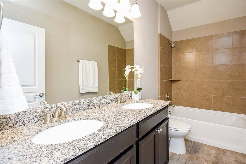 Secondary bathroom includes granite top, double sinks and tiled shower