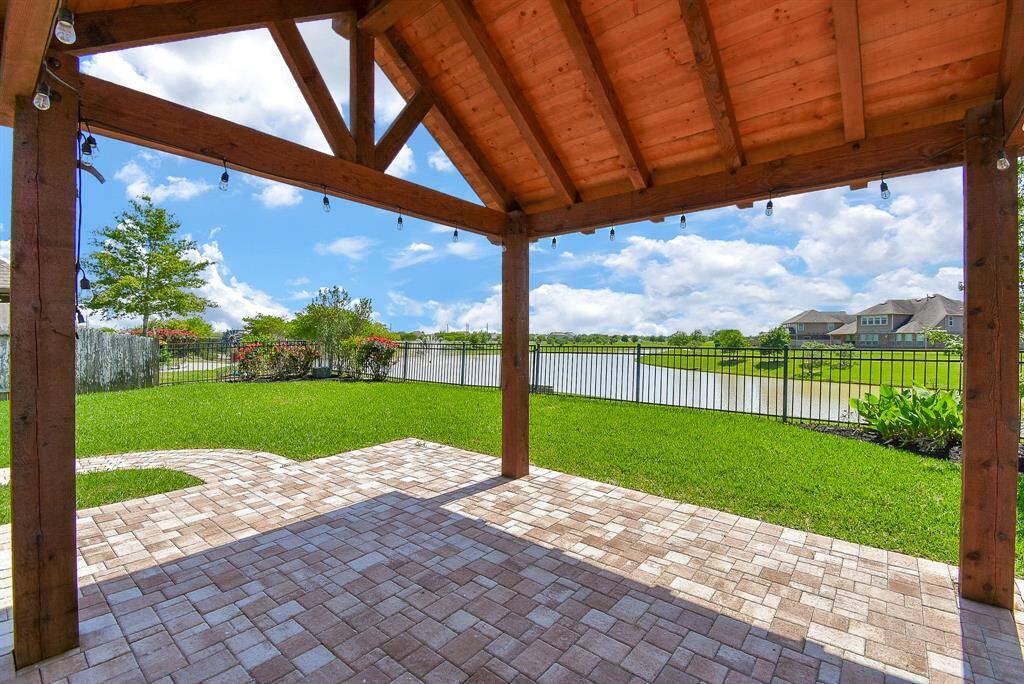 Cedar lined ceiling slats with 6x6 posts accented with a nice brick pattern that leads you to the second covered area for this backyard oasis.