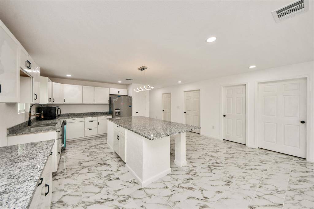 Angle from the kitchen showing the expansive counter space and plentiful cabinets, offering both style and functionality.