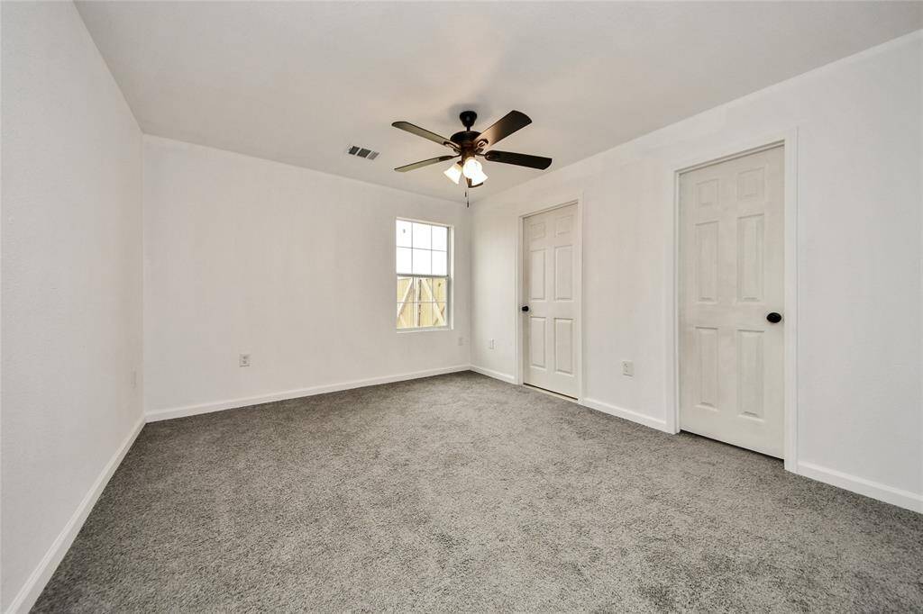 Bright and airy secondary bedroom with cozy carpeting and a large window offering natural light.