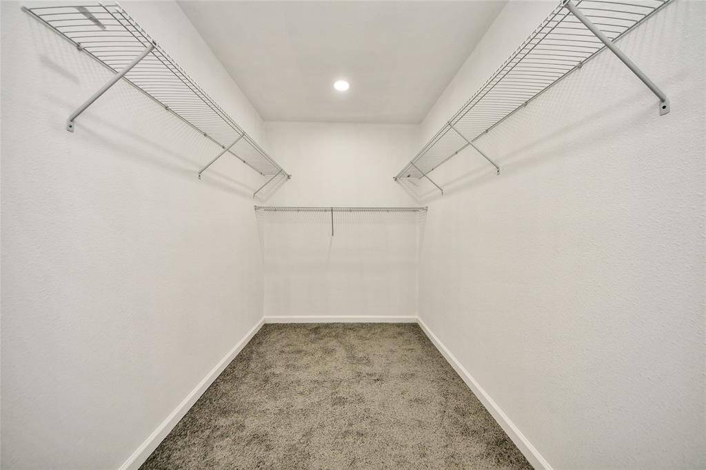 Generous walk-in closet with built-in shelving, offering plenty of storage space for an organized lifestyle.