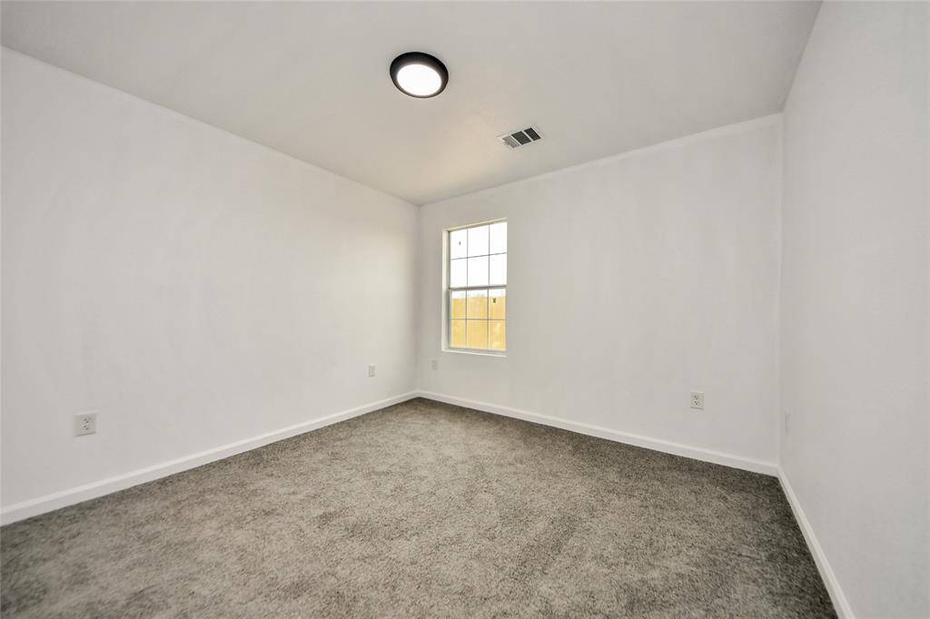 Additional secondary bedroom offering neutral finishes, perfect for a guest room, home office, or playroom.