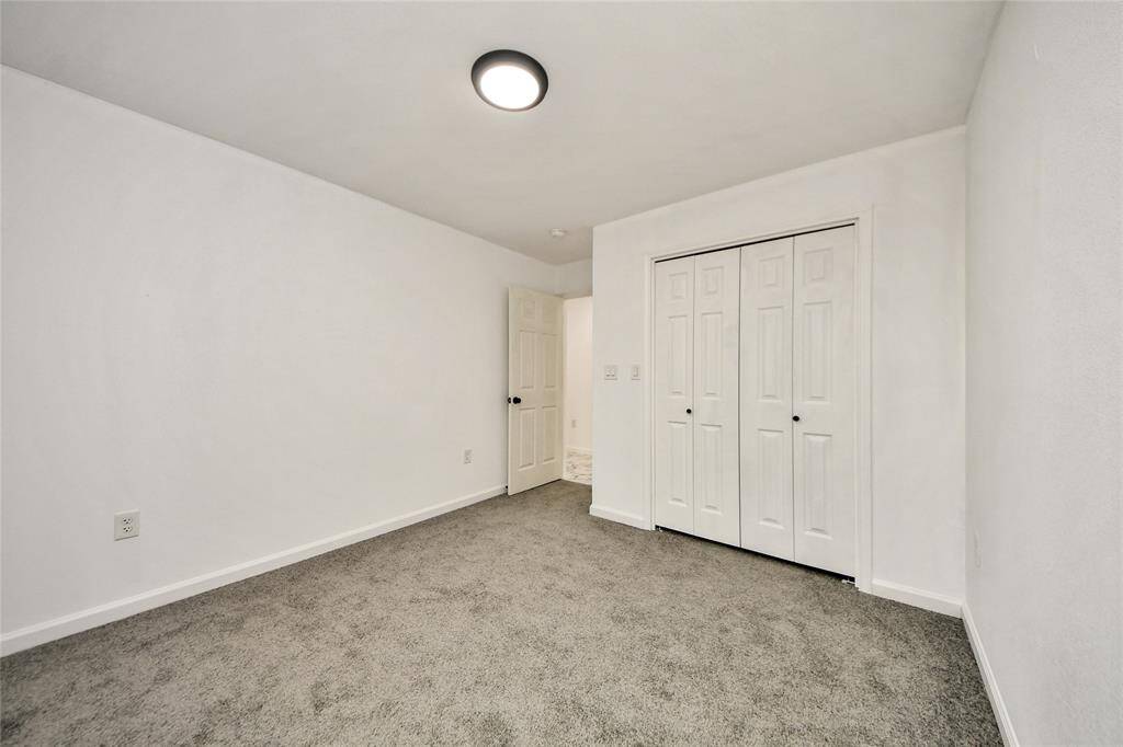 Spacious secondary bedroom offering a double-door closet and easy access to the hallway, perfect for guests or a home office.