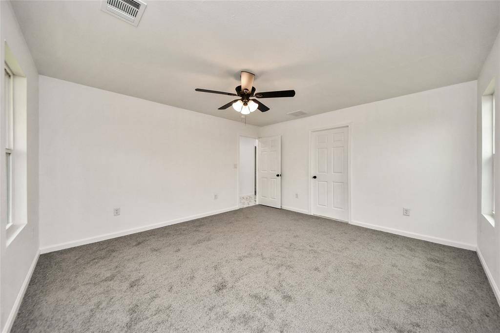 Primary suite showcases ample space, neutral palette, and direct access to a luxurious en-suite bathroom.