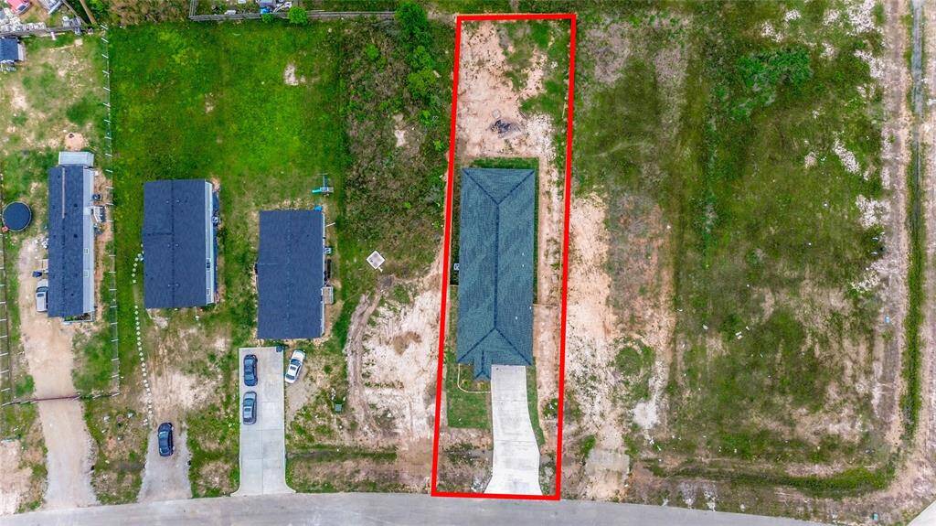 A clear aerial view outlining the property boundaries, showcasing the spacious lot with a newly constructed single-story home and a long private driveway.