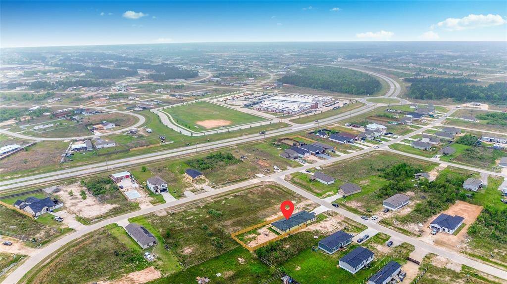 A wide aerial shot pinpointing the property's location within the growing neighborhood, highlighting its accessibility and proximity to surrounding homes.