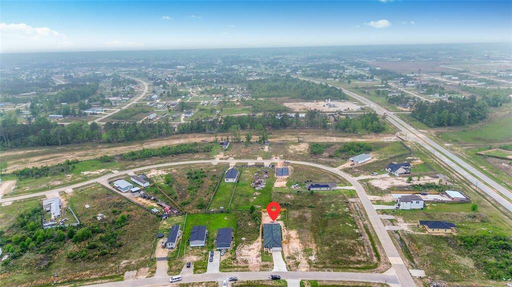 A broader aerial perspective featuring the property's location relative to nearby parks, schools, and commercial areas, emphasizing the convenient setting.
